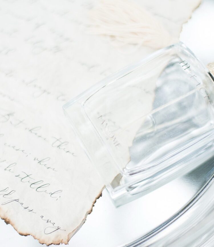 Bridal details: Perfume bottle and a handwritten love letter on a decorative background at a Florida wedding.